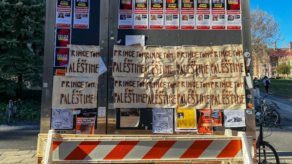 A display board outside of Frist Campus Center is pictured. On the bottom half of the board are two rows of handwritten "Princeton for Palestine" signs. The top right has printed signs for Israelis taken hostage by Hamas. 