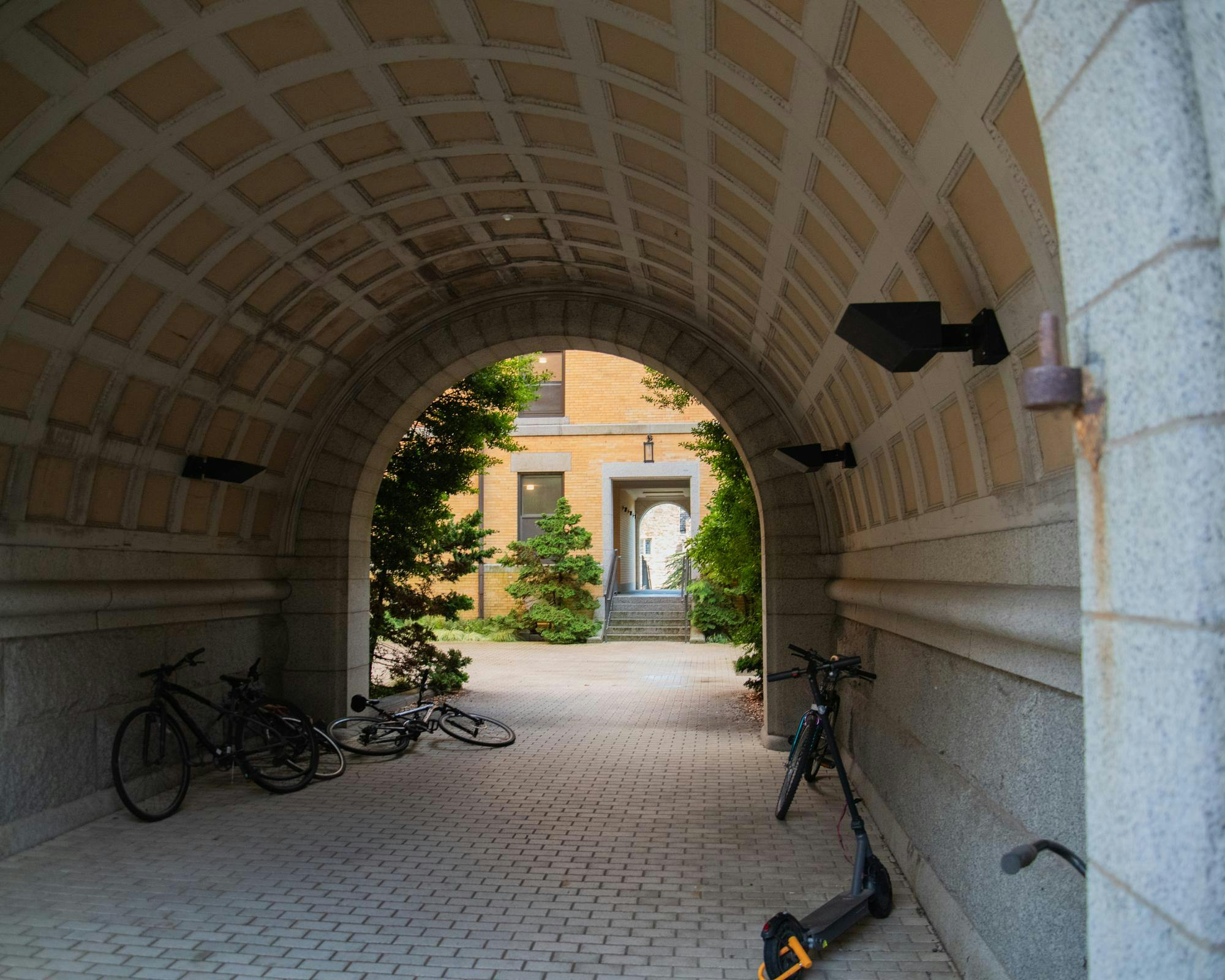 Tunnel with lights with bicycles scattered around in them. There is light at the end of the title.