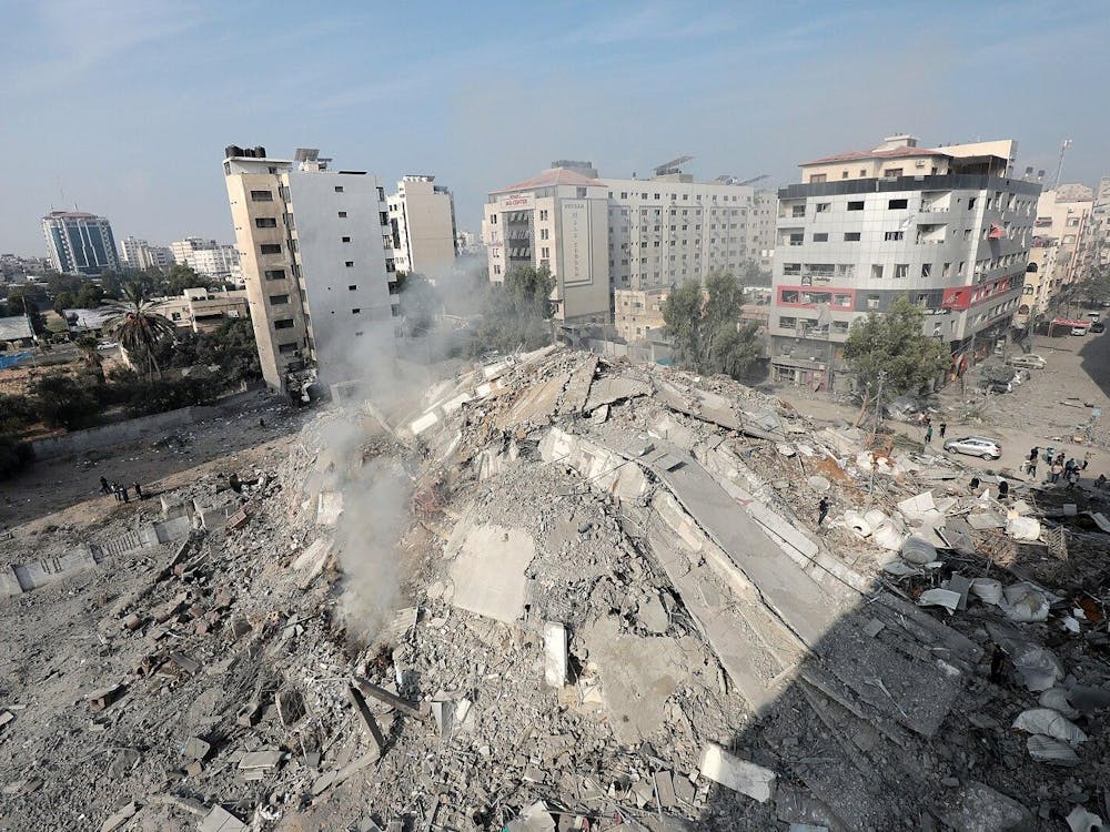 City with buildings and rubble, with smoke rising.