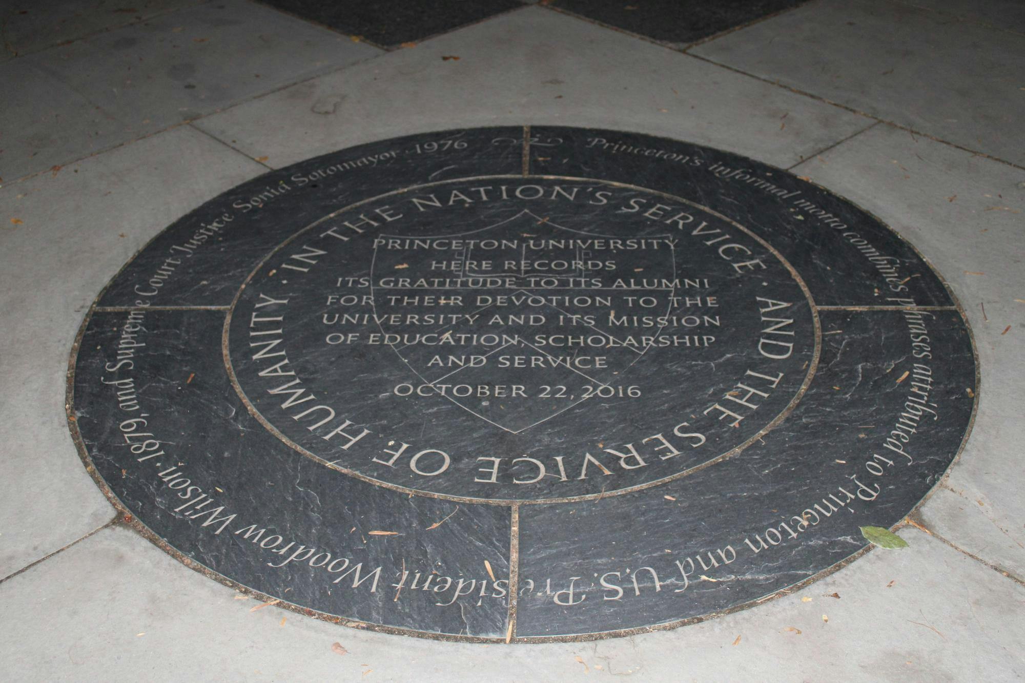 A plaque commemorating Princeton’s informal motto is on the crossover of two walkways. 