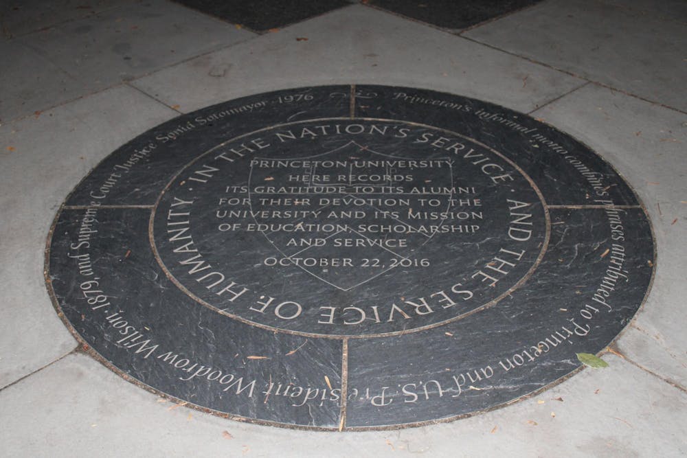 A plaque commemorating Princeton’s informal motto is on the crossover of two walkways. 