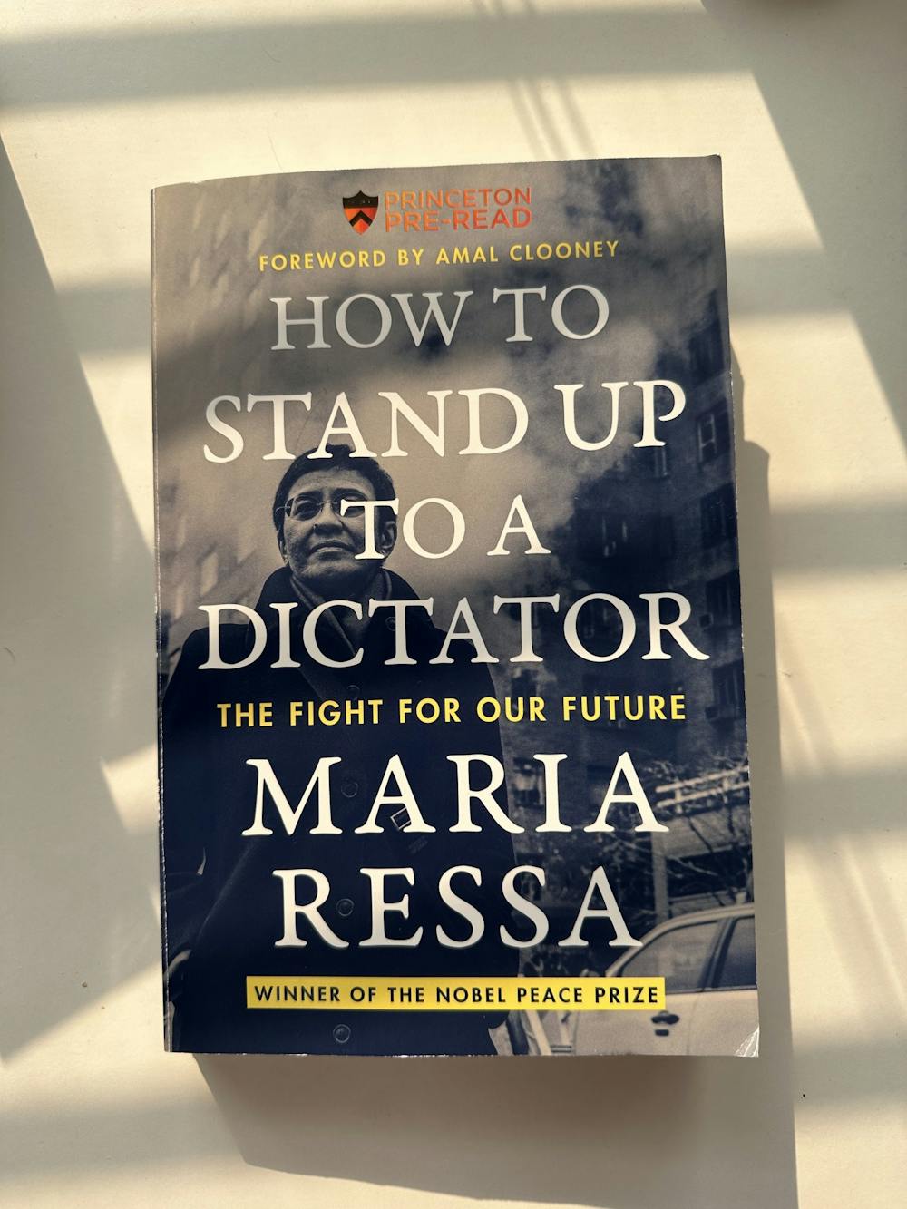 Photo of the cover of Maria Ressa's book, How to Stand Up to a Dictator. Cover is a photo of Ressa color-corrected to blue overlaid in with title in large white text.