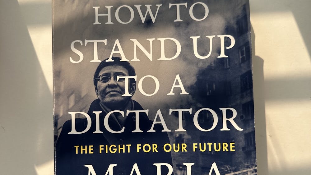 Photo of the cover of Maria Ressa's book, How to Stand Up to a Dictator. Cover is a photo of Ressa color-corrected to blue overlaid in with title in large white text.