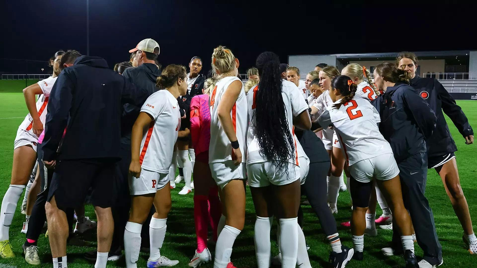 Players in white shirts huddle and put their hands in the middle after the loss.
