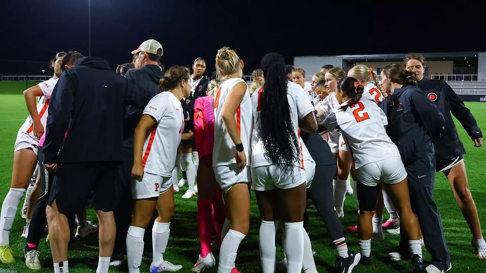 Players in white shirts huddle and put their hands in the middle after the loss.