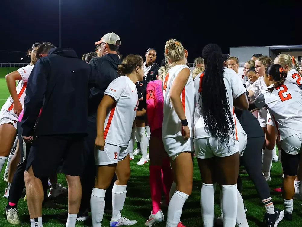 Players in white shirts huddle and put their hands in the middle after the loss.