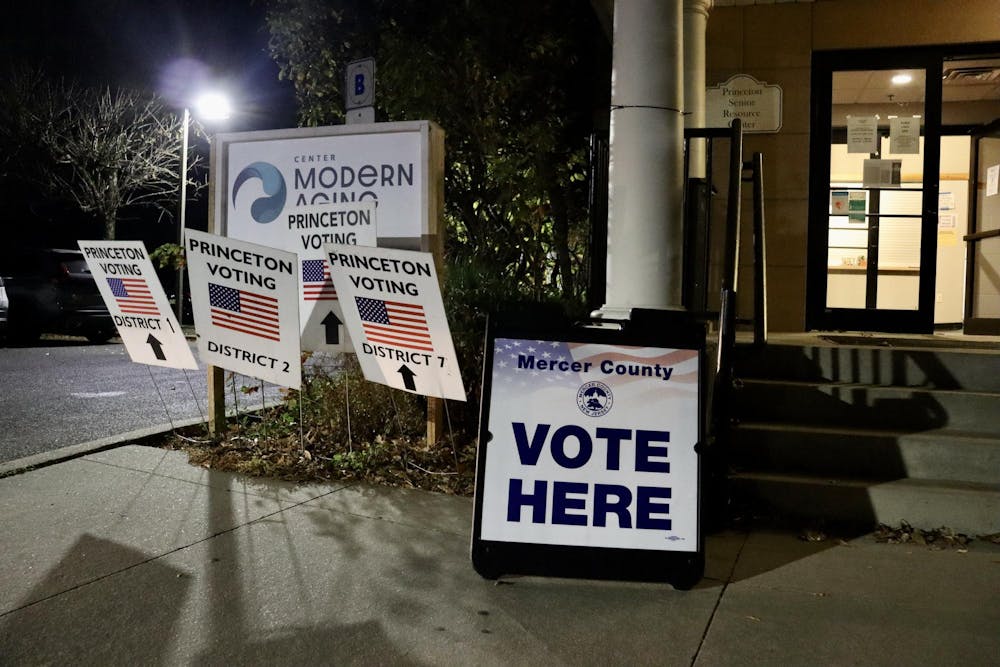 A large red, white, and blue sign reading "Mercer County vote here" outside a polling place.