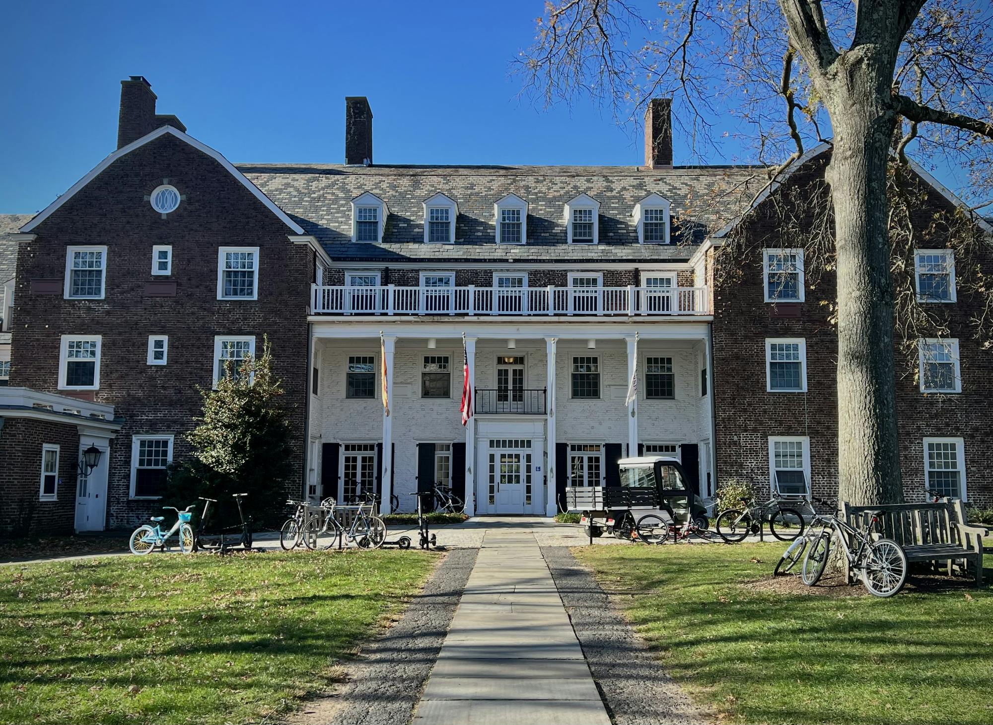 Bikes are parked in front of a brick building with a white door.