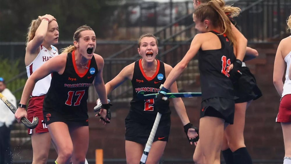 Field hockey players celebrating on field.