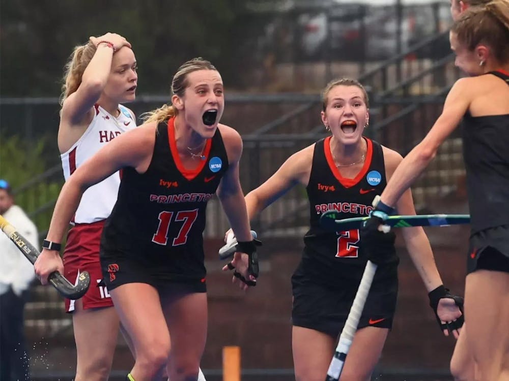 Field hockey players celebrating on field.