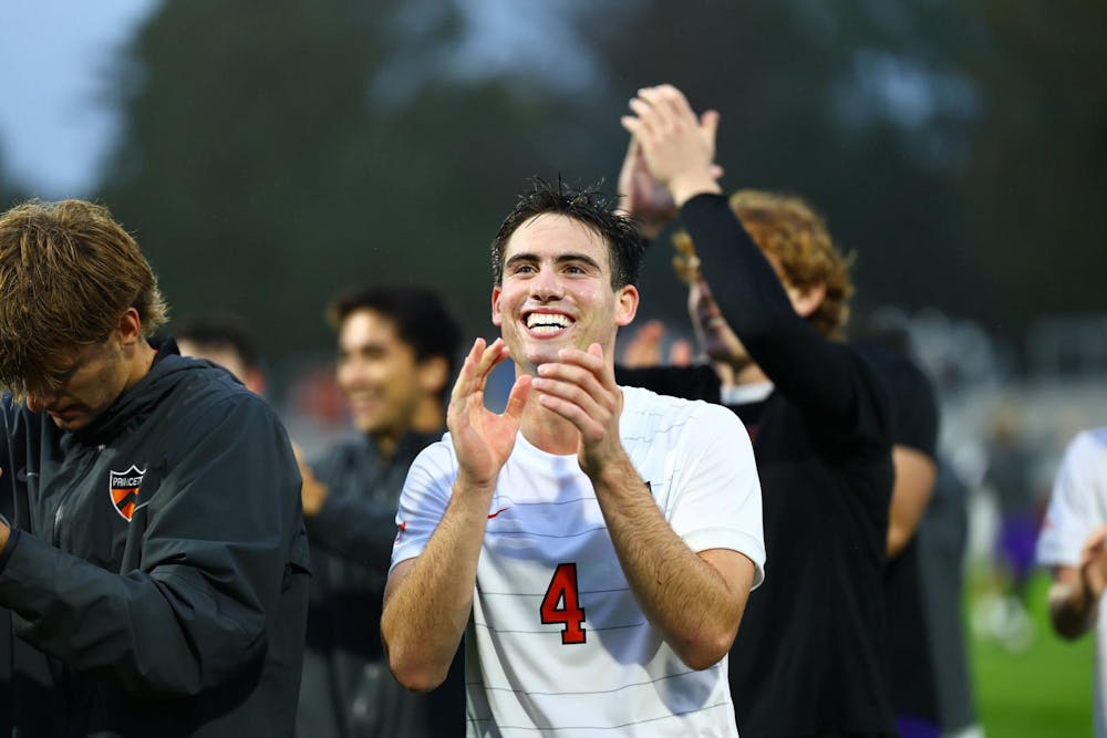 Men in white soccer jerseys celebrate a win.