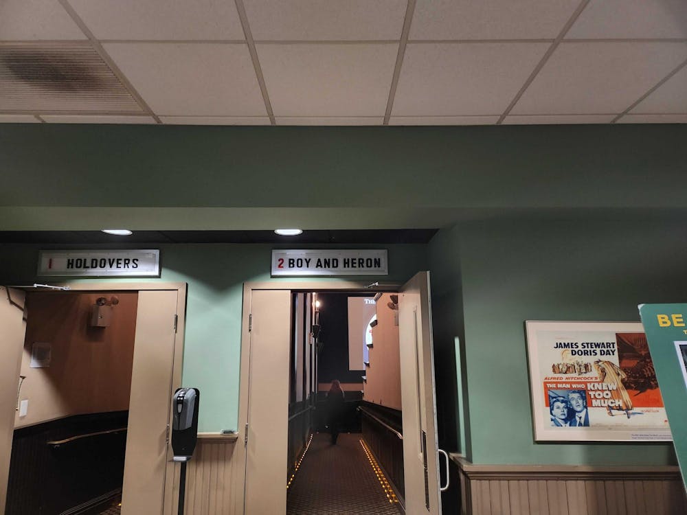 An open door into a theatre. Above the door is a sign that says "2 Boy and Heron"