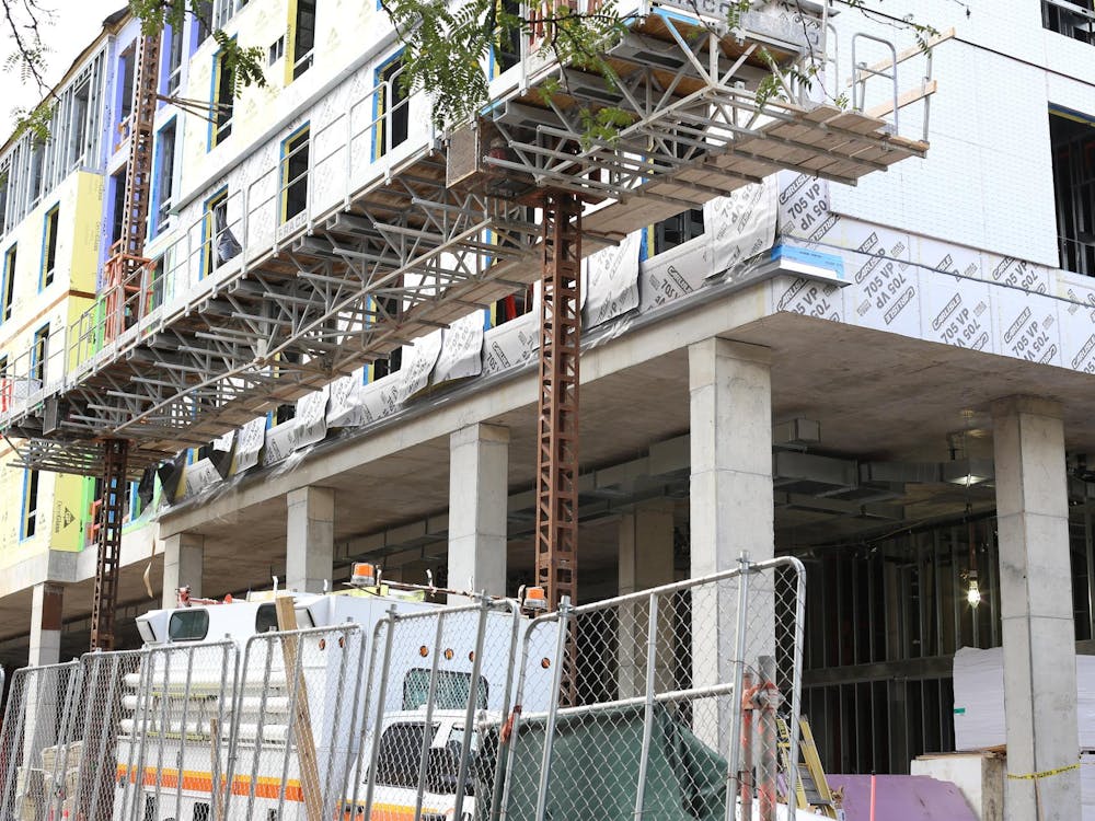 The Graduate Hotel in Princeton under construction. A fence surrounds a metal building being constructed. A construction truck sits behind the fence.