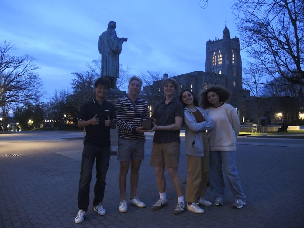 Five students standing in a plaza.