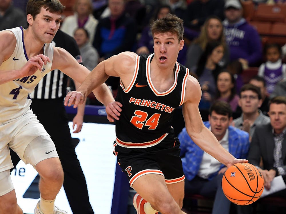 Man runs down a court dribbling a basketball.