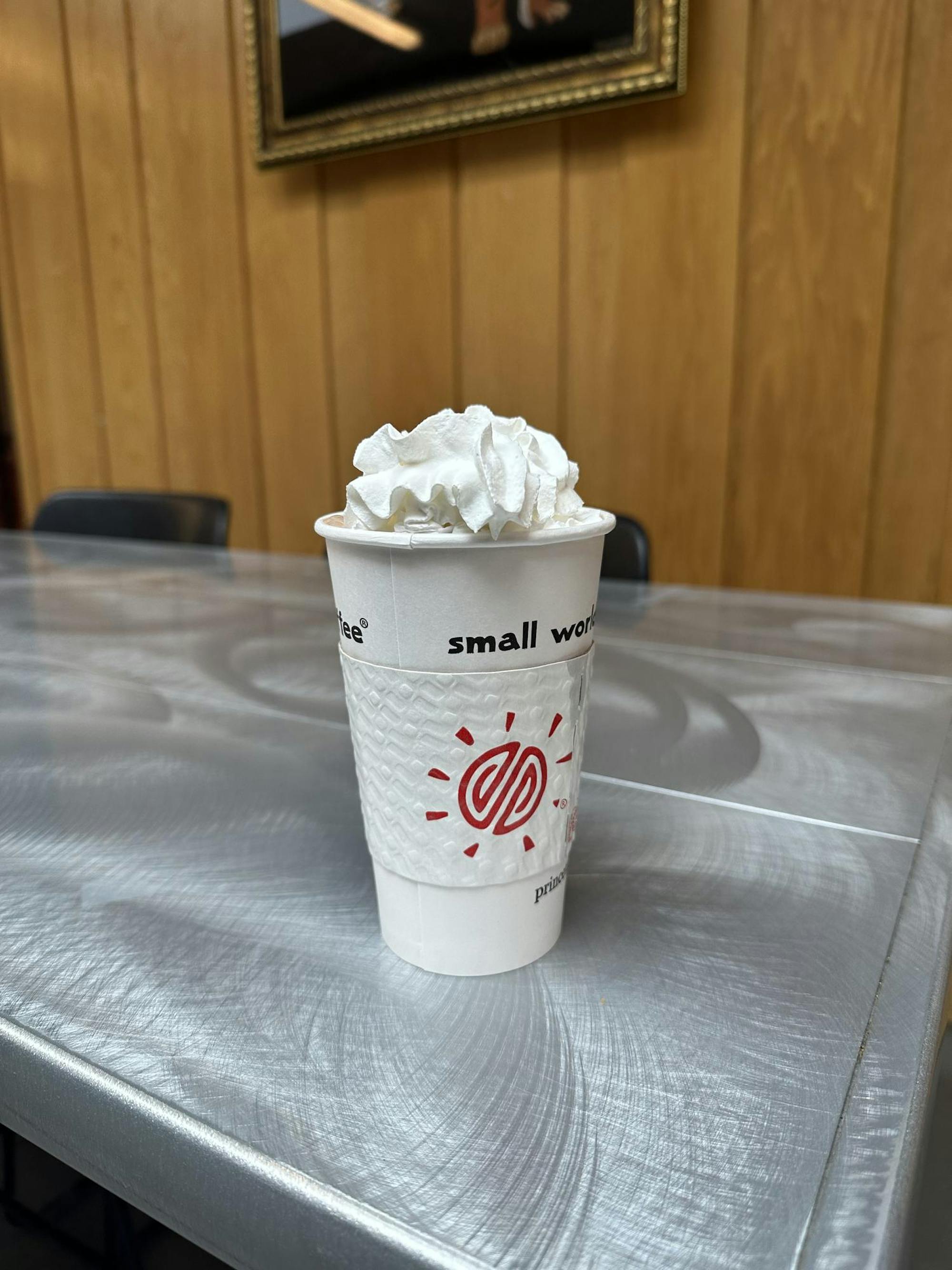 White cup of hot chocolate with whipped cream on top.