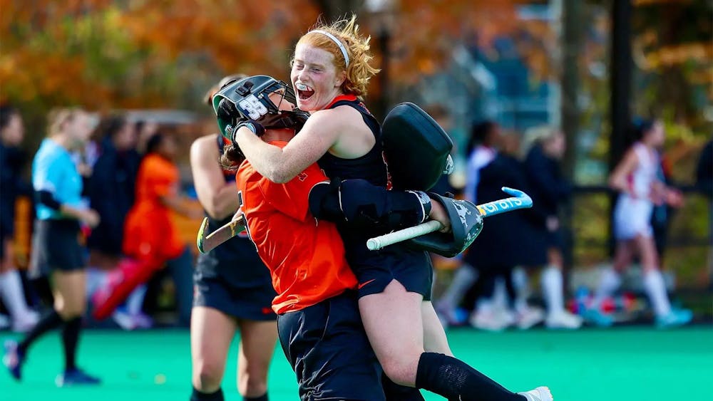 Field hockey players celebrating on field.