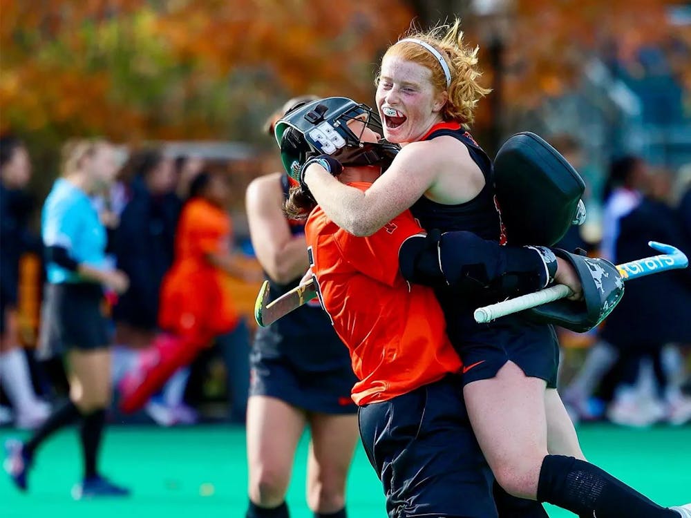 Field hockey players celebrating on field.