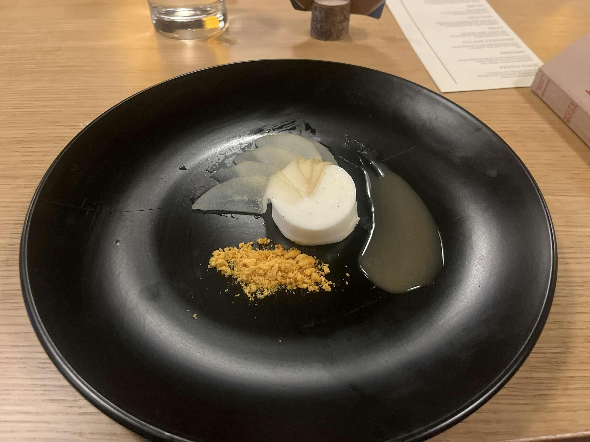 A white circular cylinder is on a black plate.