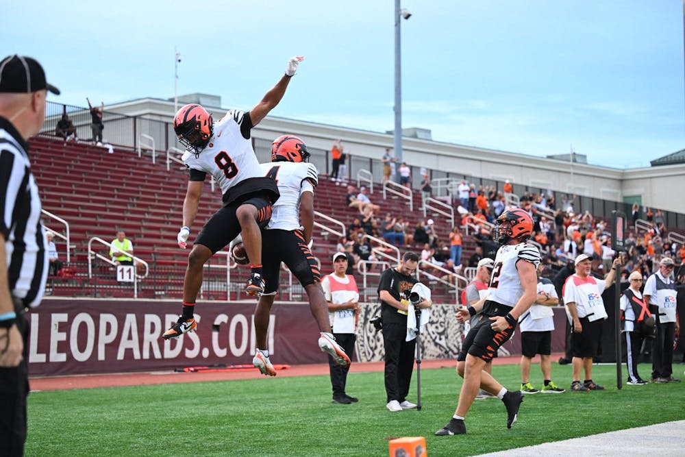 Football players jumping in the air celebrating.