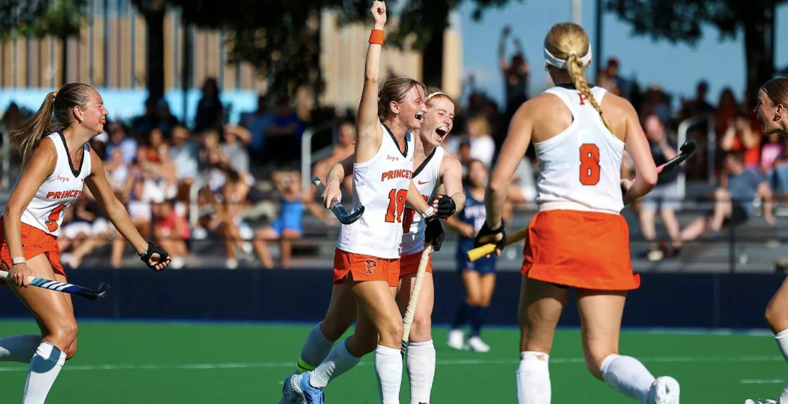 A group of players in orange and white jerseys celebrating a goal