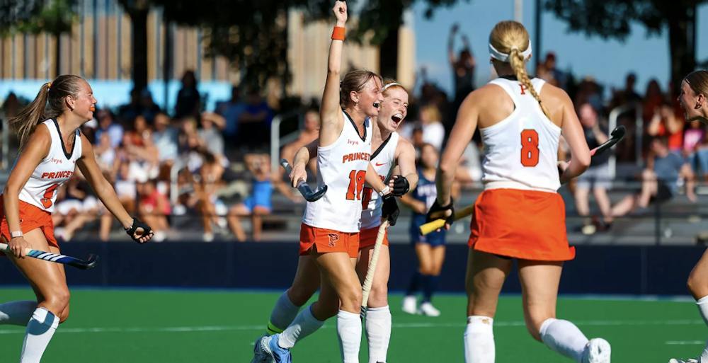 A group of players in orange and white jerseys celebrating a goal