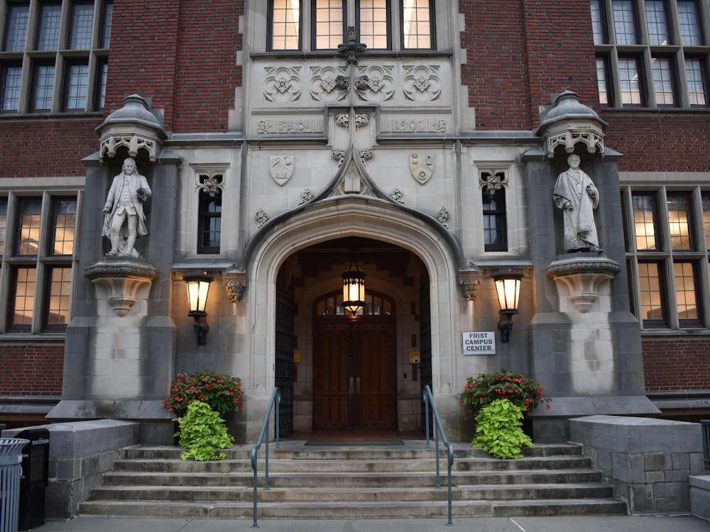 A set of front doors, preceded by an archway with a sign reading 'Frist Campus Center.'