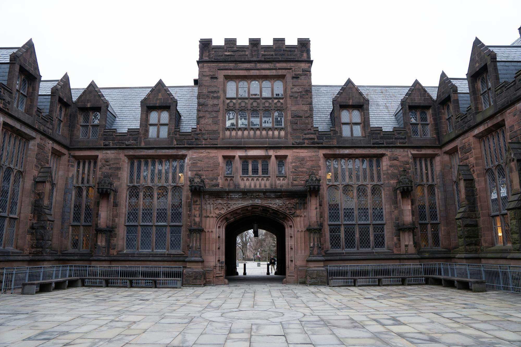A large, dark stone building looms in front of a gray sky.