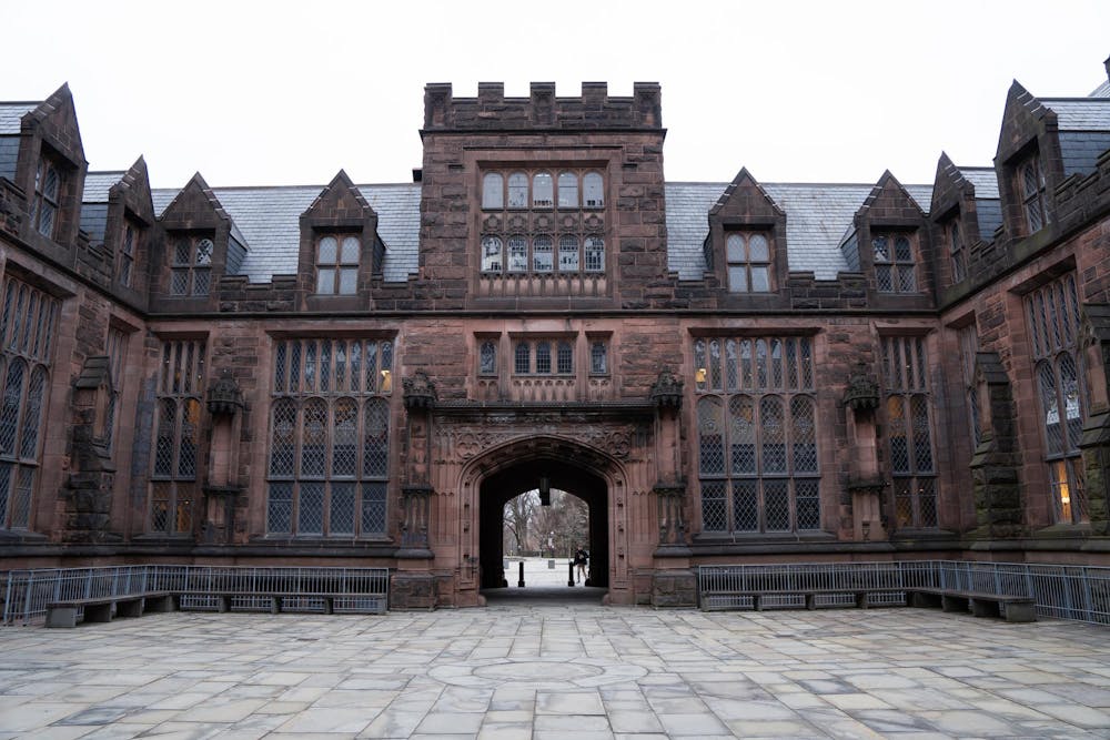 A large, dark stone building looms in front of a gray sky.