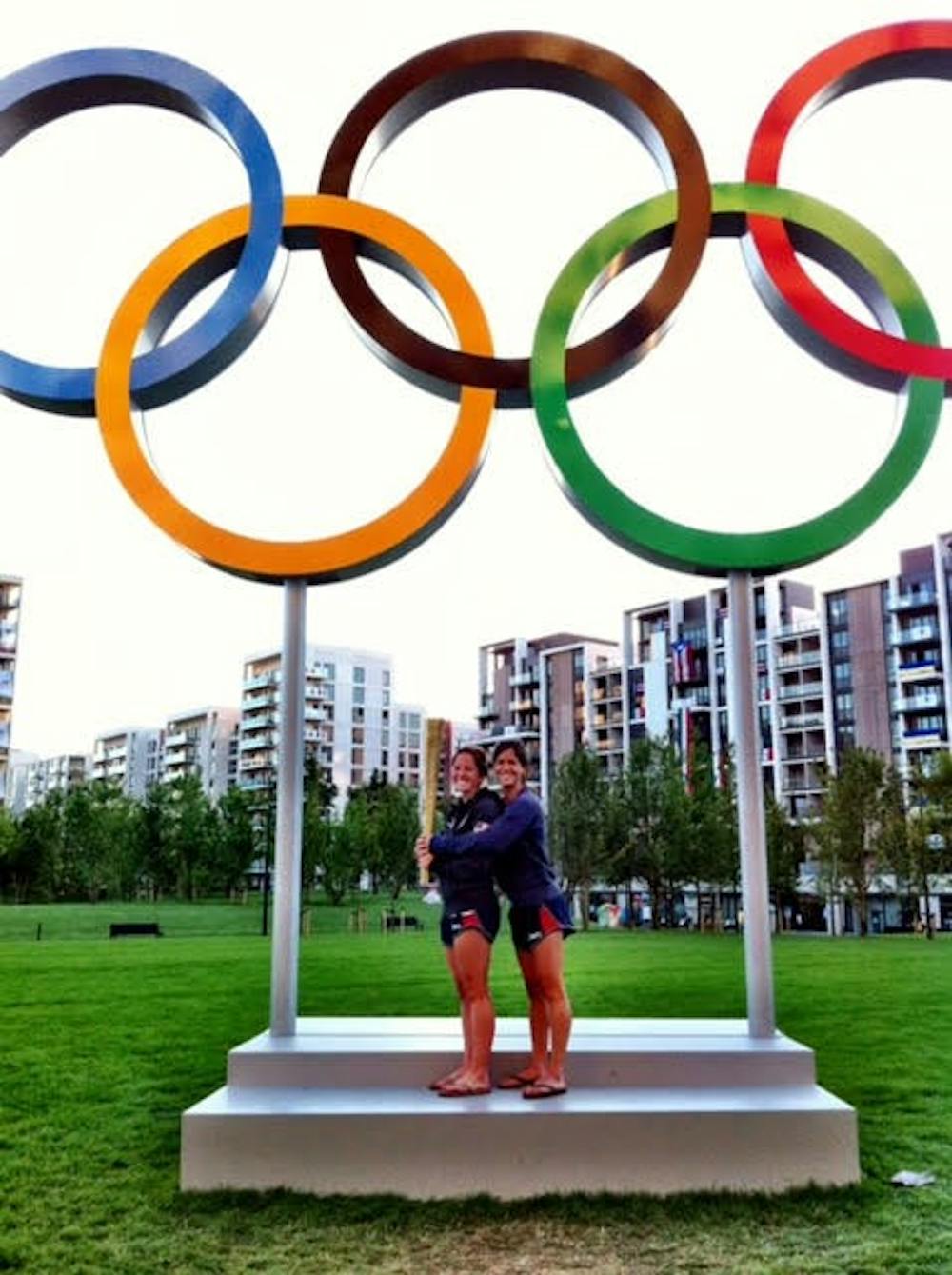 &nbsp;Julia Reinprecht ’14 and Katie Reinprecht ’13 with Olympic Torch and Rings at the Athlete Village.