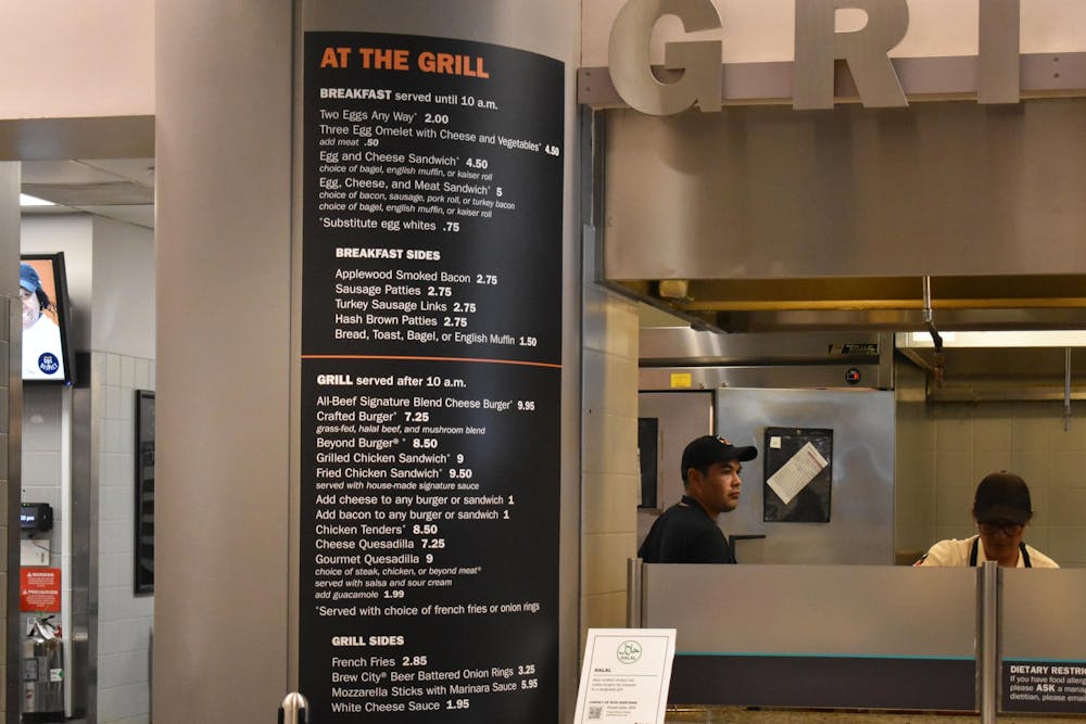 Grill station menu is on the right of the photo and a worker to the left.