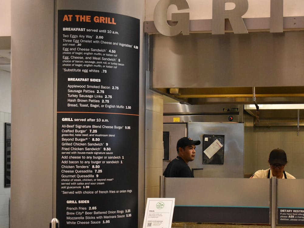 Grill station menu is on the right of the photo and a worker to the left.