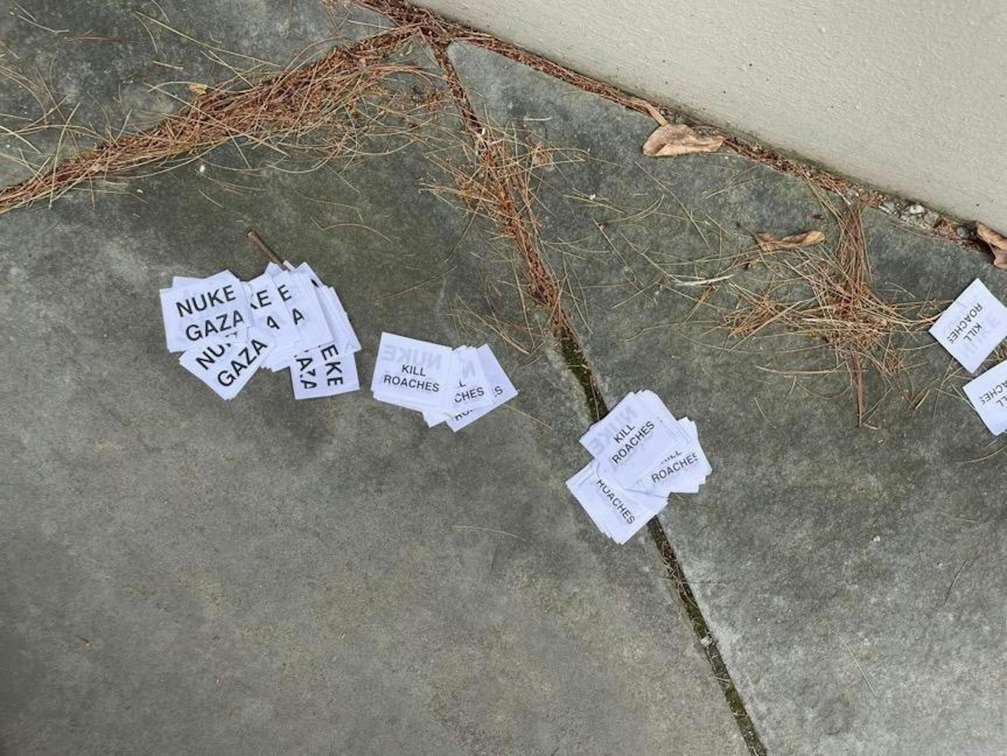 Small rectangular paper cutouts reading "Nuke Gaza" and "Kill Roaches" in capital letters.