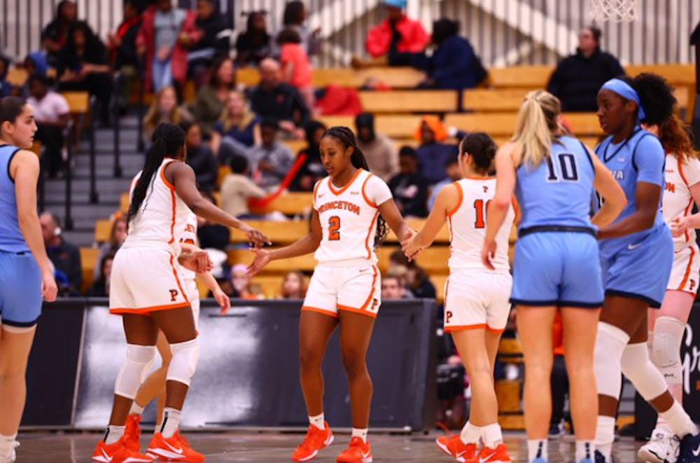 Princeton women’s basketball high-fiving on the court.