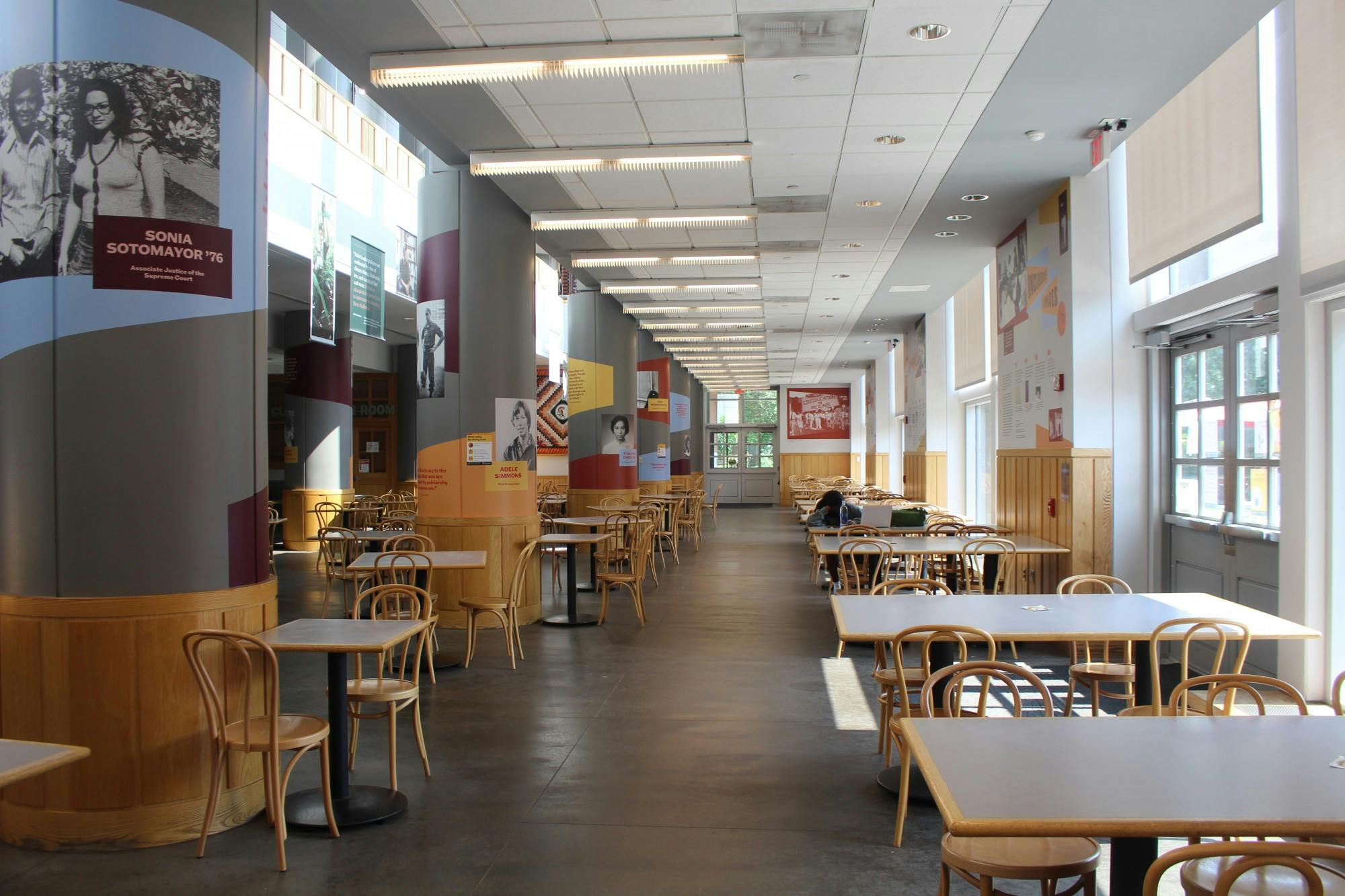 Empty tables except for one student studying.