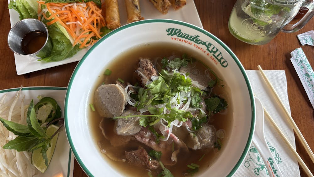 A variety of colorful dishes and drinks are on a brown table.