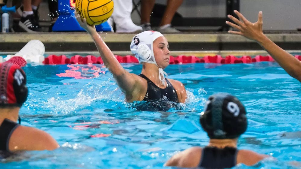 Women in water throwing water polo ball.