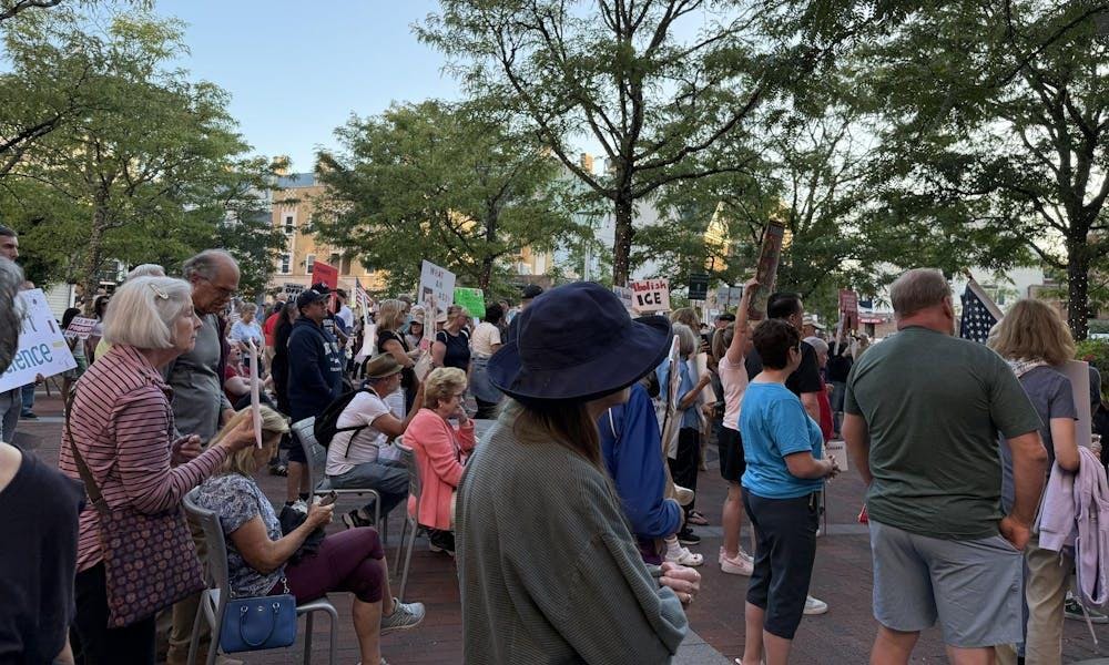 Miembros de la comunidad tienen carteles con mensajes en contra de las acciones de ICE. 