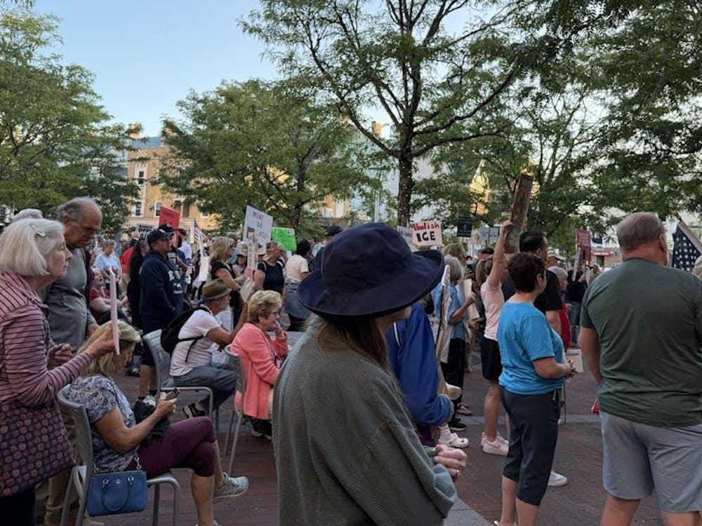 Miembros de la comunidad tienen carteles con mensajes en contra de las acciones de ICE.
