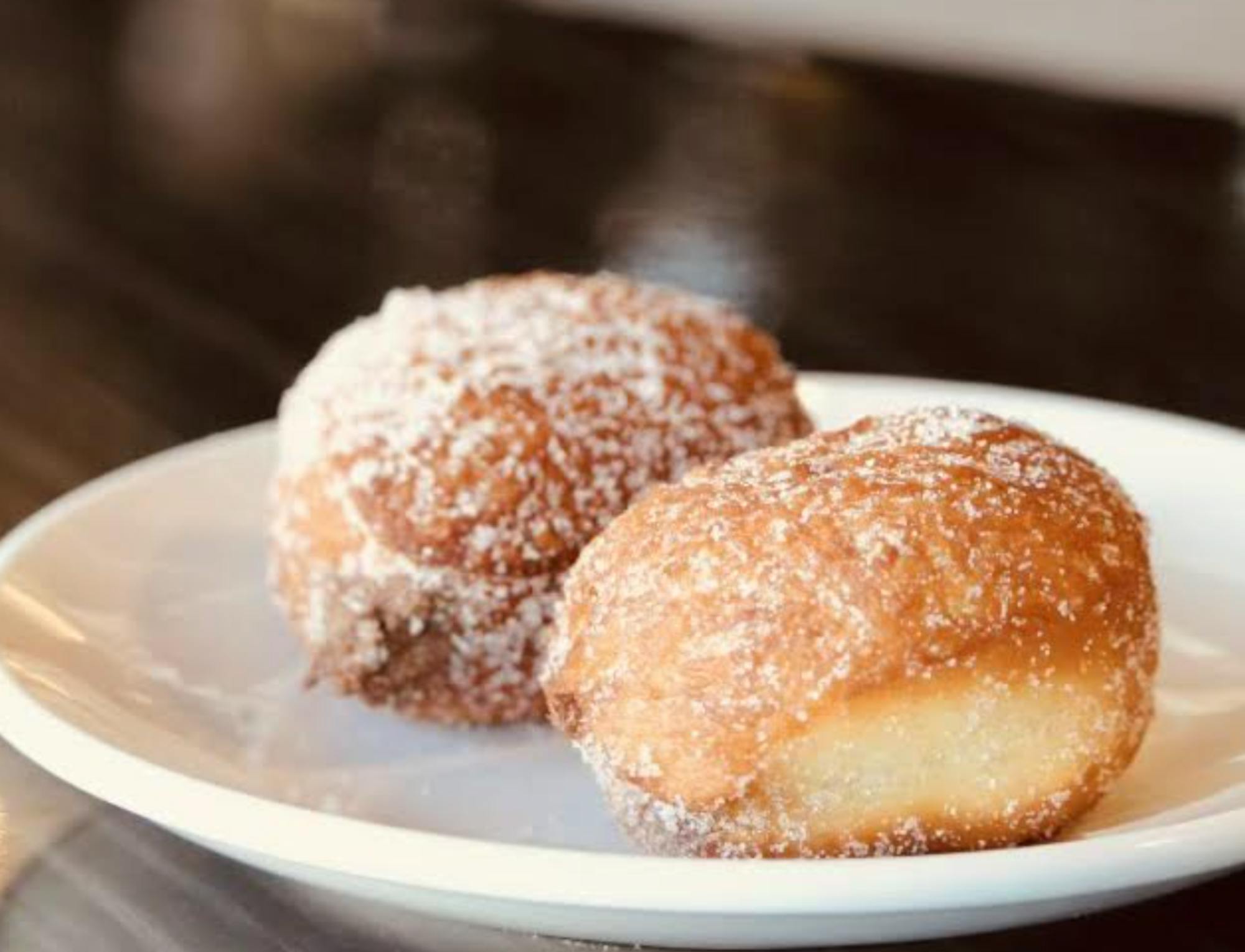 Two sugary pastries sit on a plate.