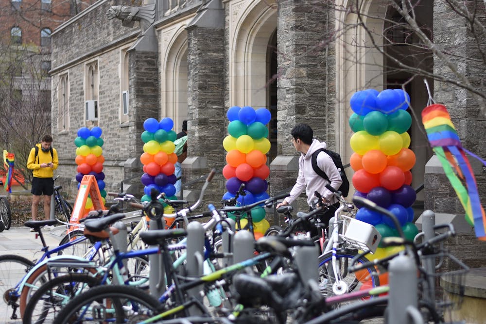 Building with rainbow balloons in front, with a full bike rack in the foreground.