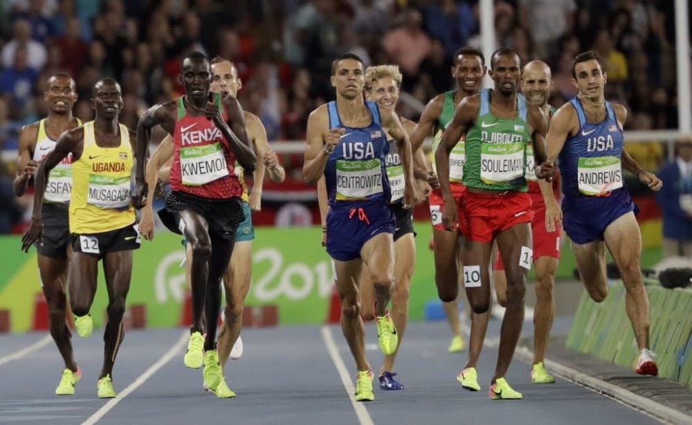  U. assistant track and field coach Robby Andrews (right) steps off the track around the 1450m mark, which ultimately led to his disqualification from the men's 1500m event.