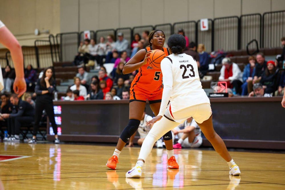 Princeton player looks to pass while being guarded by a Brown player.