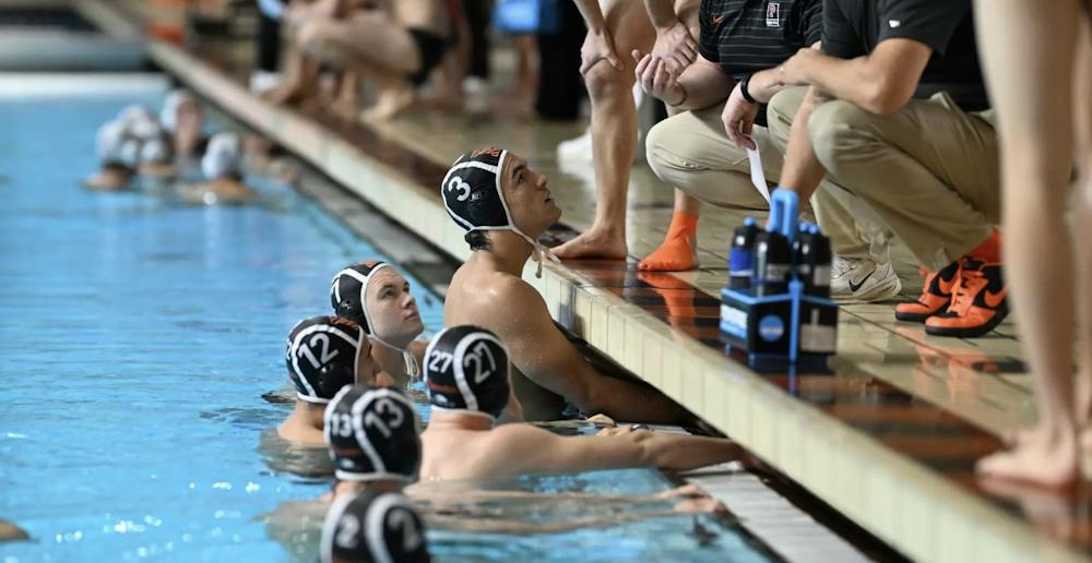 Men’s water polo players huddling up for a game plan.