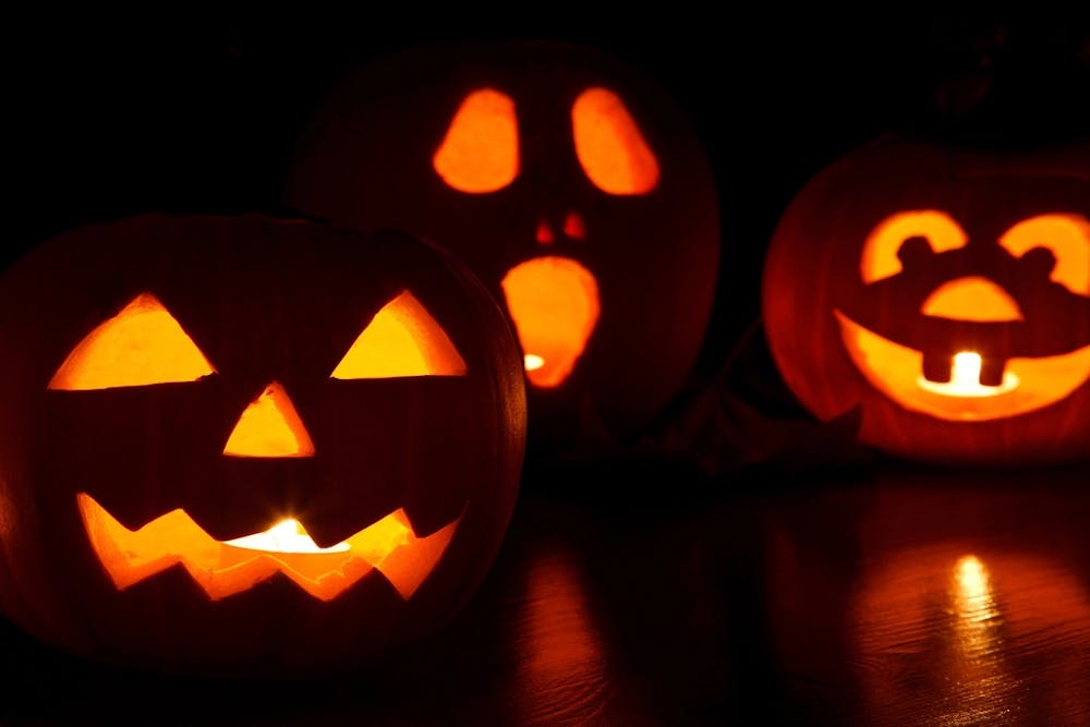 Three carved pumpkin lanterns with candles inside them. 