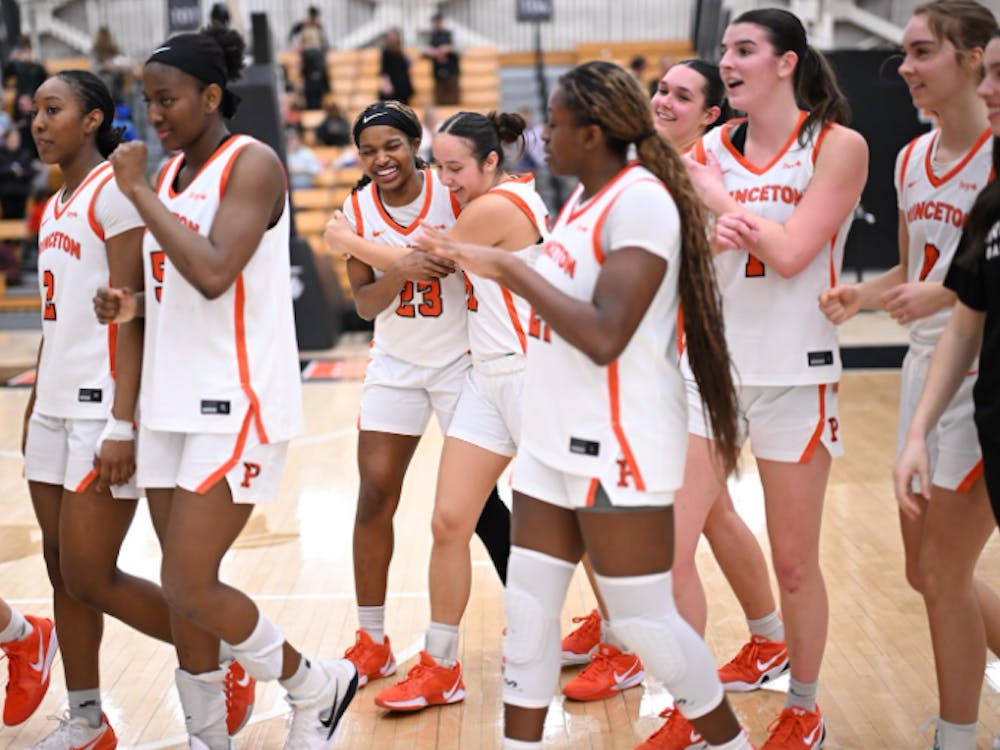 Players in white jerseys walk across a basketball floor.