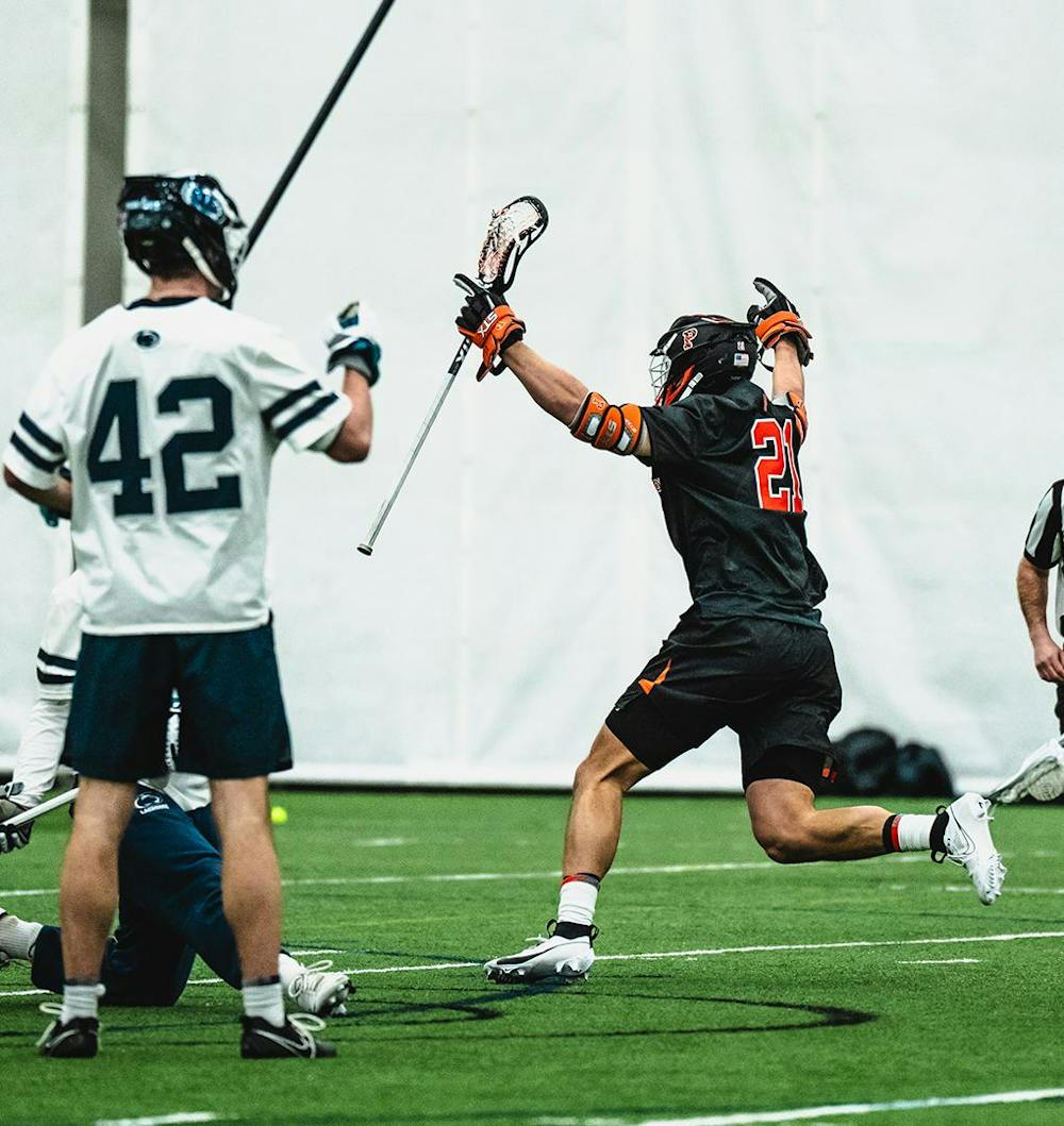 Lacrosse player running in celebration.