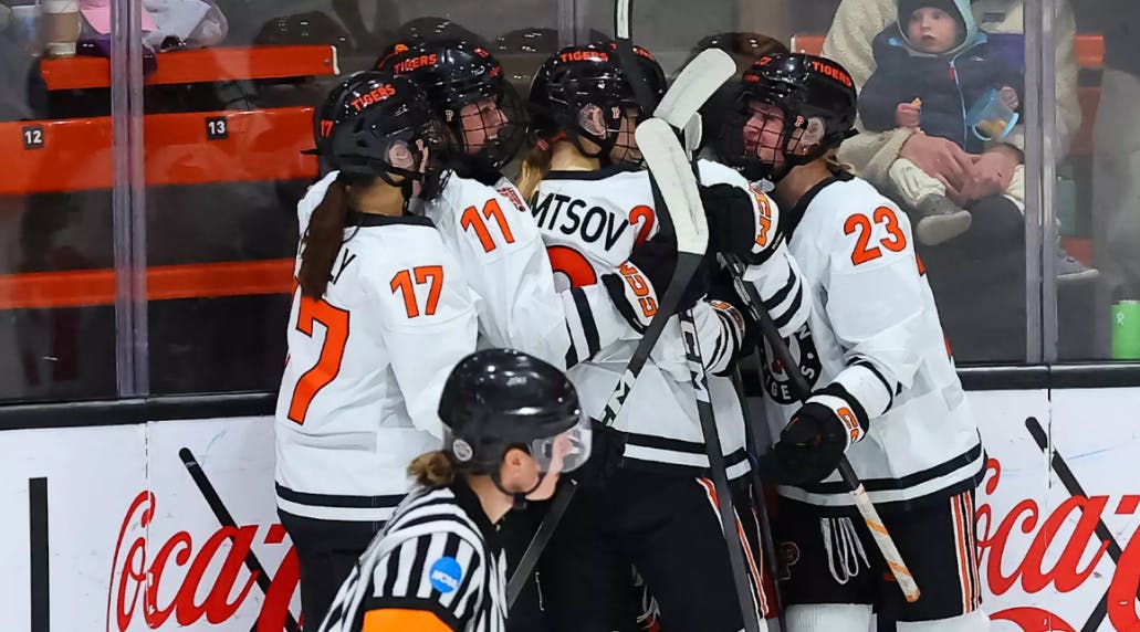 Princeton women's hockey team celebrating in a huddle after a goal.
