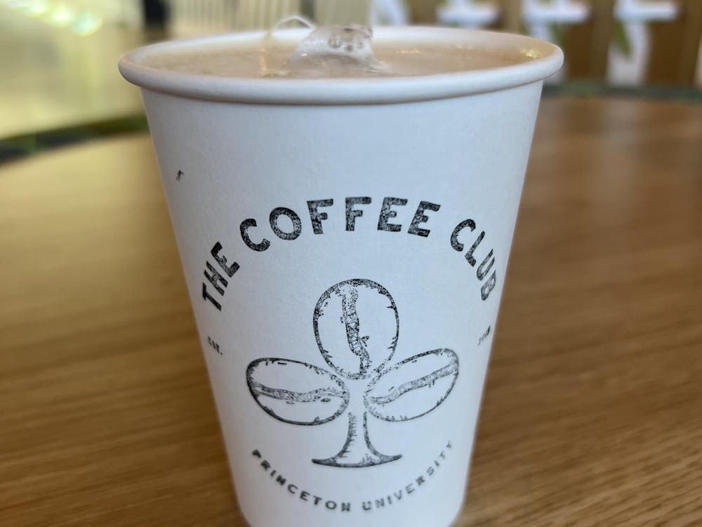 A close-up photo of a coffee cup with the words "The Coffee Cup" and coffee beans printed on the side of the cup.