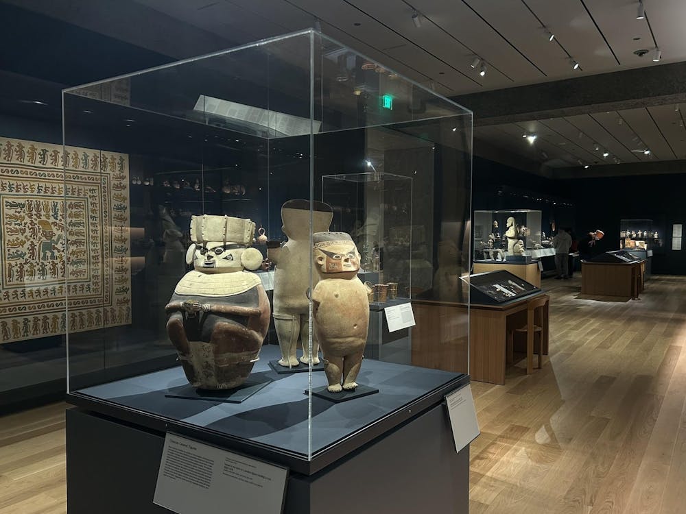 An image with a display of three ceramic figurines in the foreground with the rest of the gallery in the background.